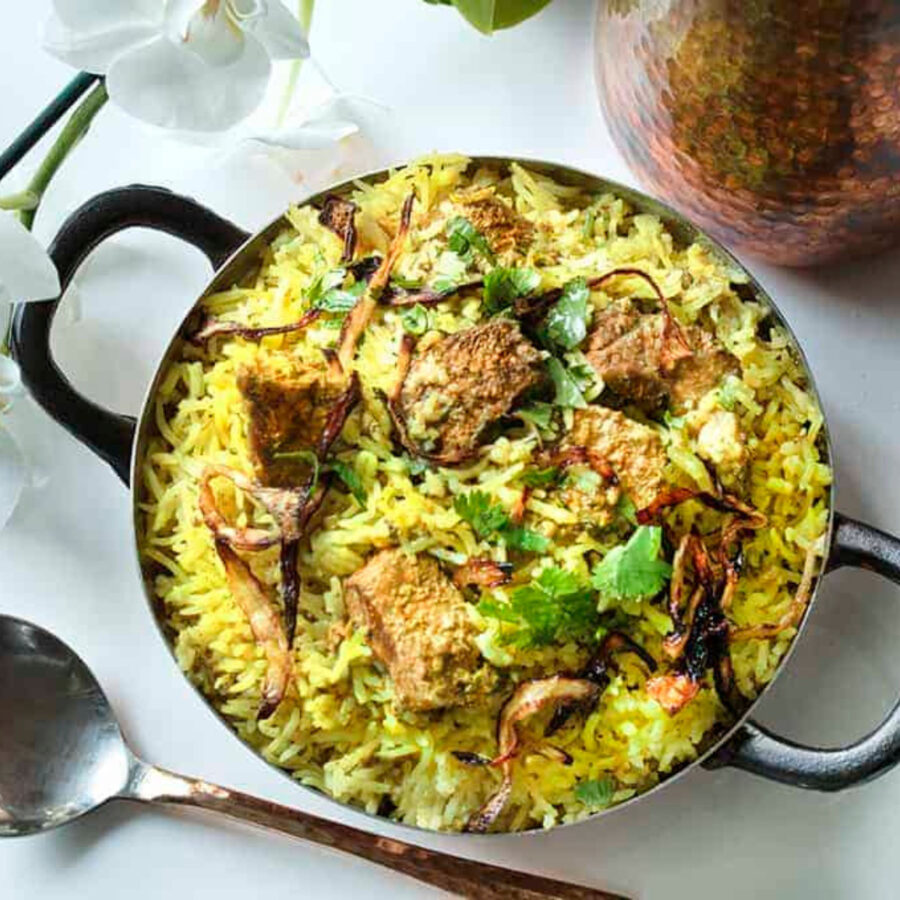 overhead image of lamb biryani in a metal dish