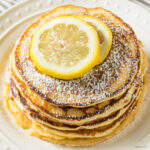 Overhead image of lemon ricotta pancakes with slices of lemon on top