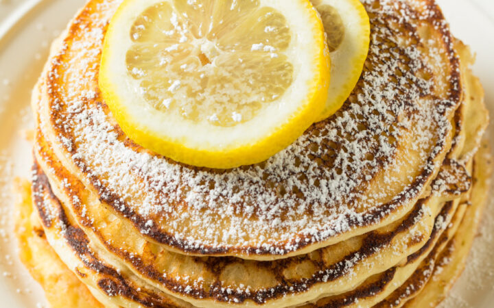 Overhead image of lemon ricotta pancakes with slices of lemon on top