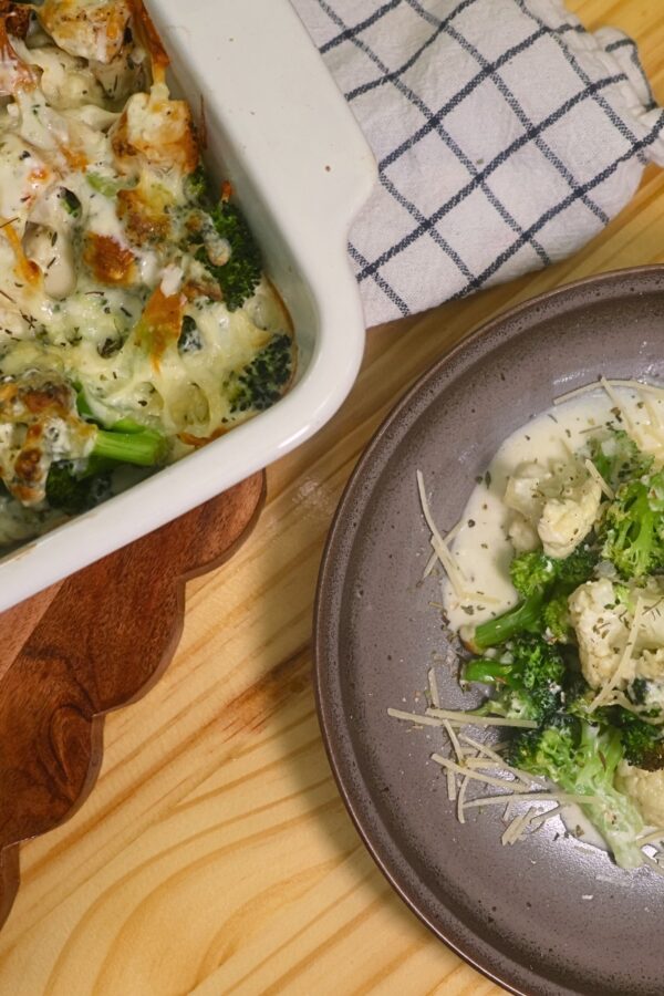 Overhead image of a plate of low carb chicken alfredo next to a baking dish full of it