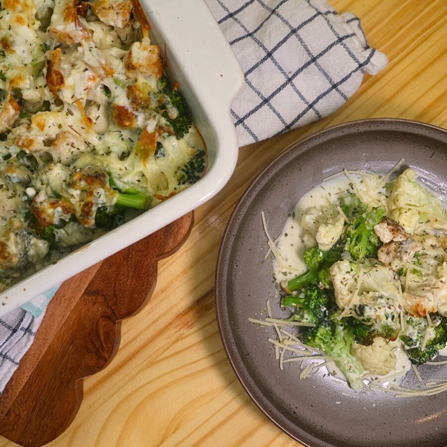 Overhead image of a plate of low carb chicken alfredo next to a baking dish full of it