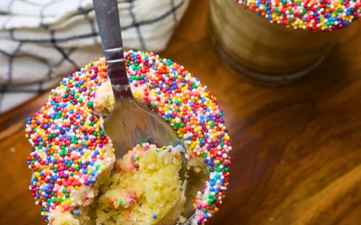 Two mini dot cakes in glasses with a spoon in one