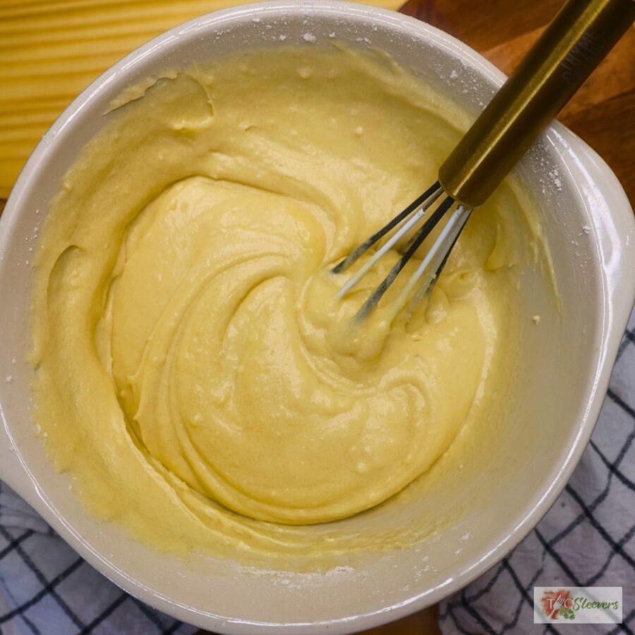 Cake batter in a mixing bowl with a whisk