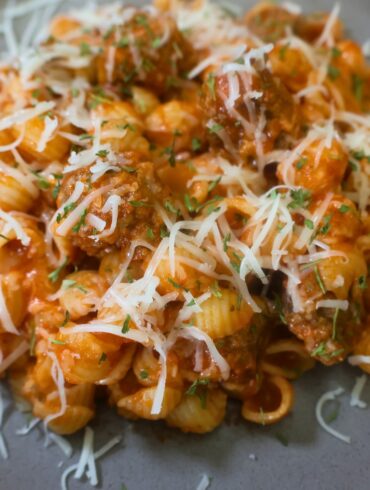 Close up image of Mini Meatball Pasta on a plate with cheese garnish
