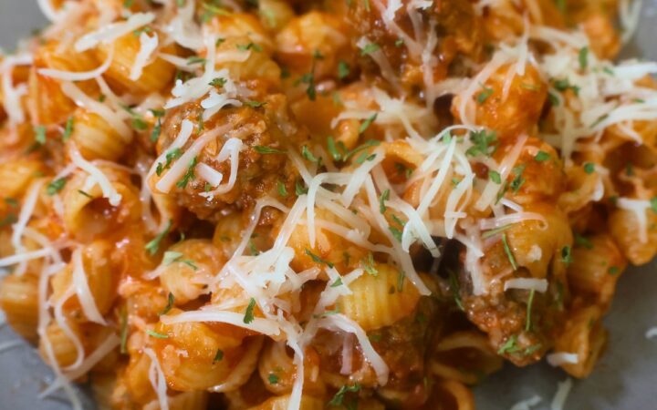 Close up image of Mini Meatball Pasta on a plate with cheese garnish