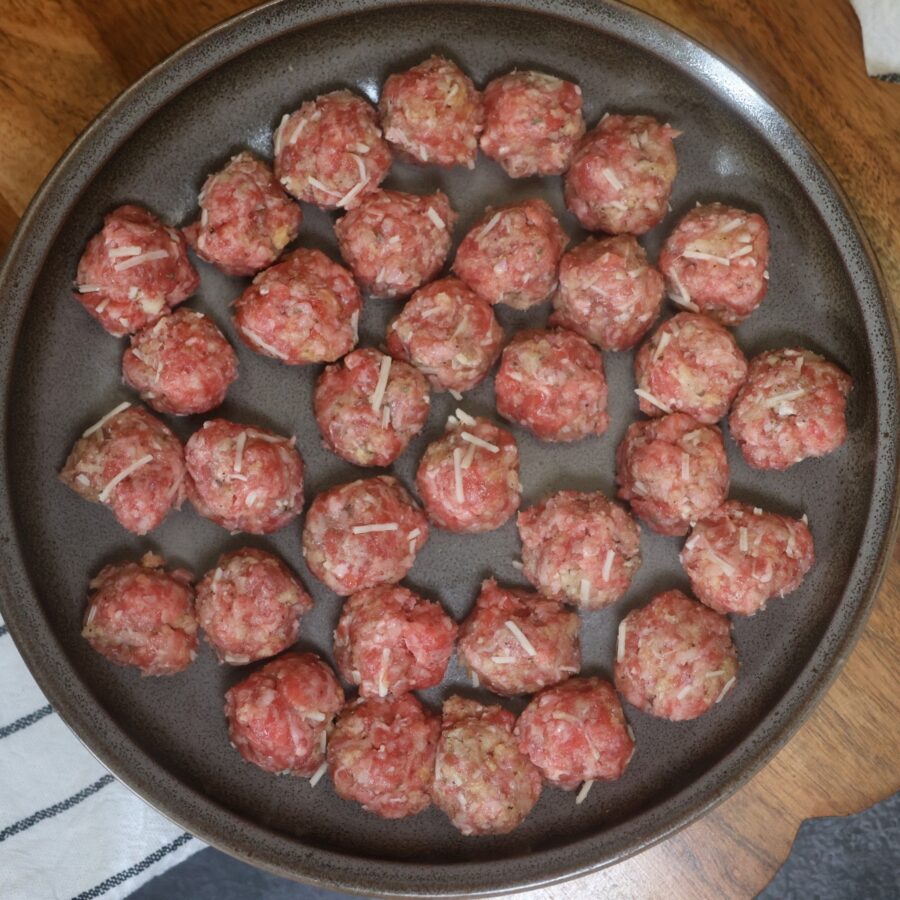 Uncooked mini meatballs on a plate