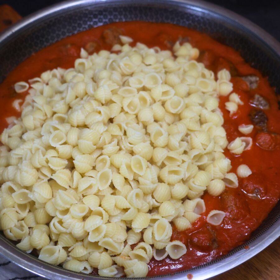 Mini meatballs and marinara sauce with cooked pasta poured in