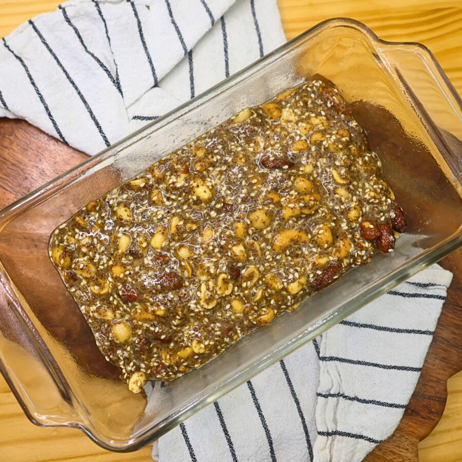 Batter for nut and seed bread poured in a prepared glass baking dish