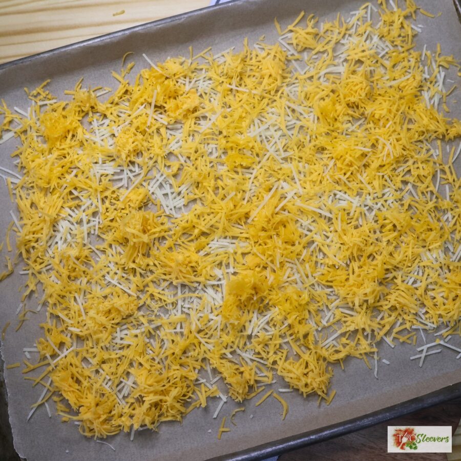 Shredded cheese on a parchment paper lined pan