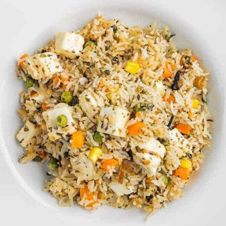 Overhead image of paneer biryani in a white dish