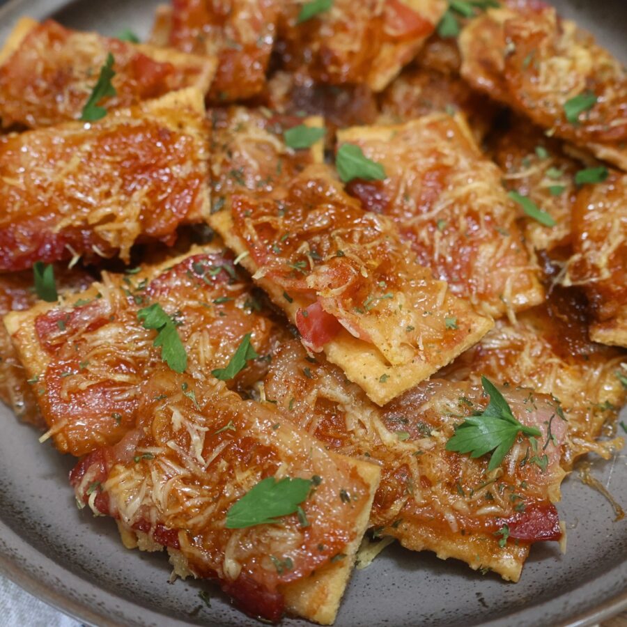Baked Parmesan Candied Bacon Crackers on a plate with parsley garnish