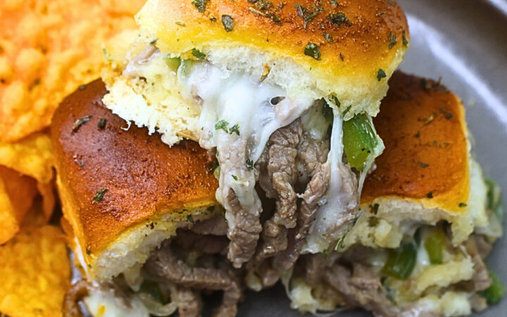 Close up image of Philly Cheesesteak Sliders on a plate with chips