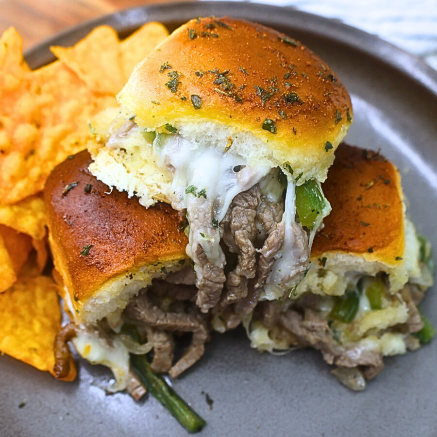 Close up image of Philly Cheesesteak Sliders on a plate with chips