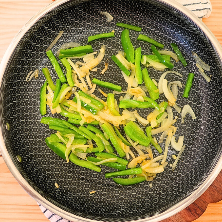 Cooked onion and peppers in a skillet