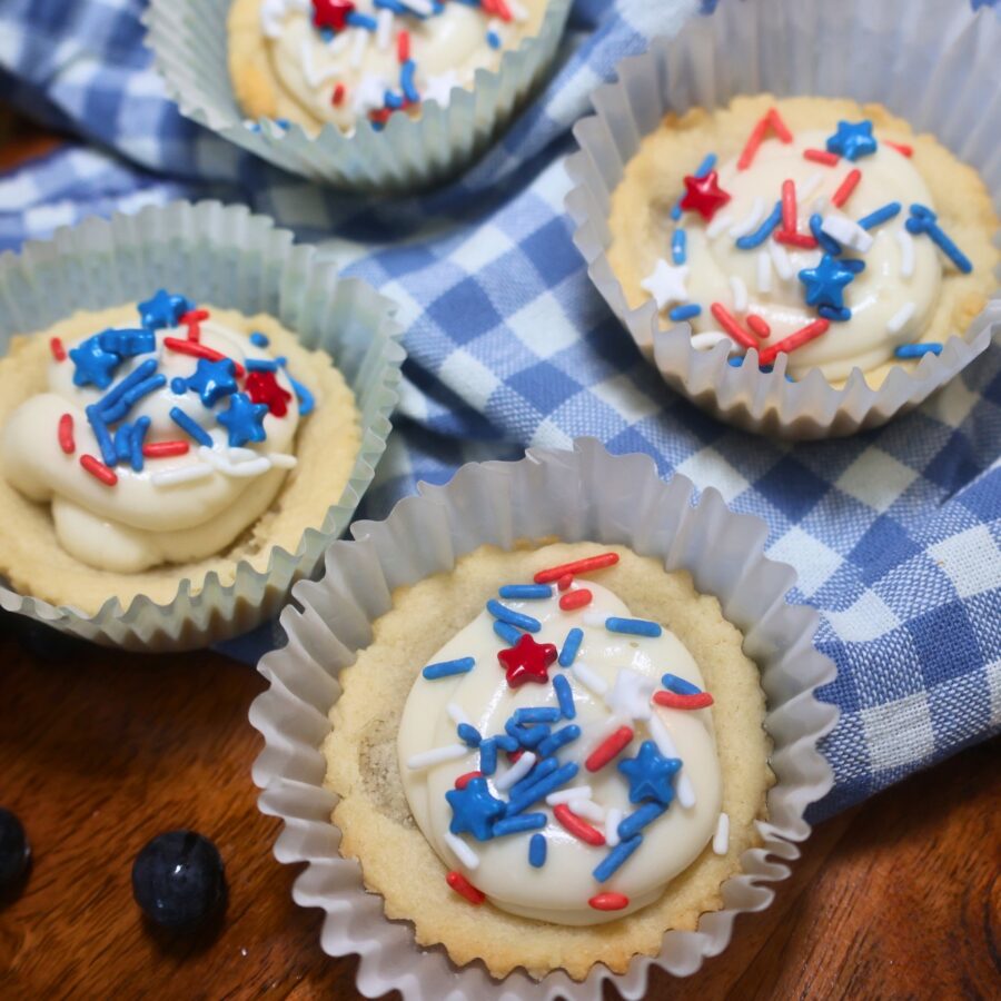 Close up image of red, white, and blue sugar cookie cups with patriotic sprinkles