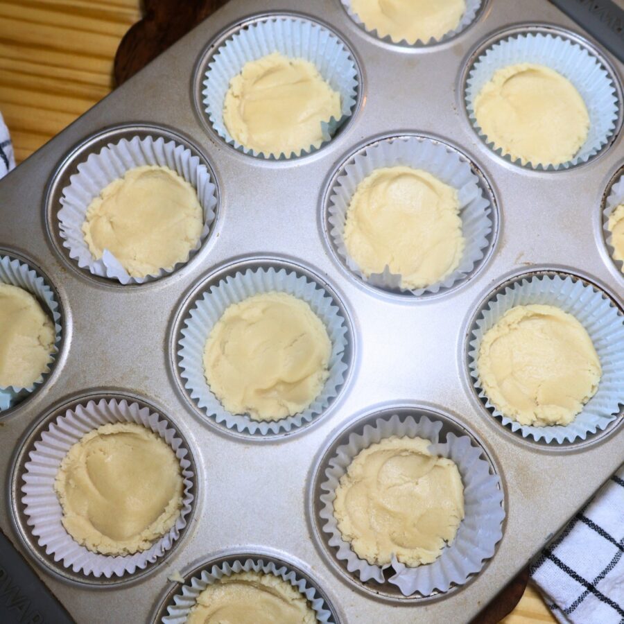 Sugar Cookie dough pressed into lined muffin tins
