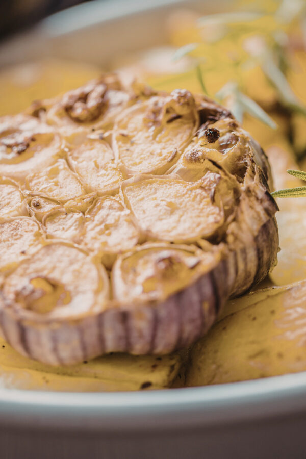 Close up image of a head of roasted garlic on a plate