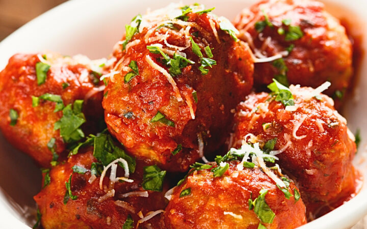 Close up image of slow cooker meatballs in a white bowl