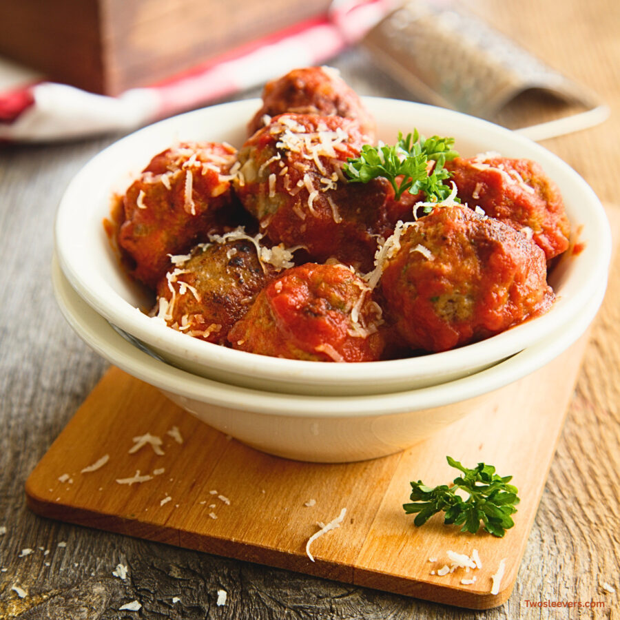 Slow Cooker Meatballs in a white bowl on a cutting board