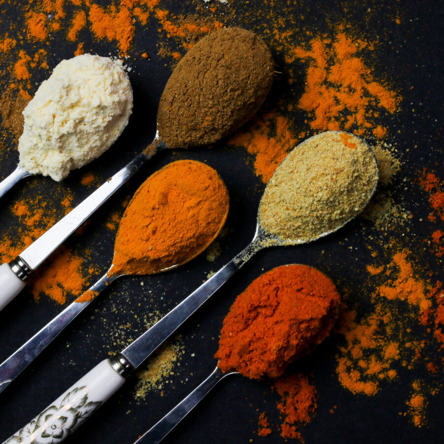 Spices in spoons on a dark background