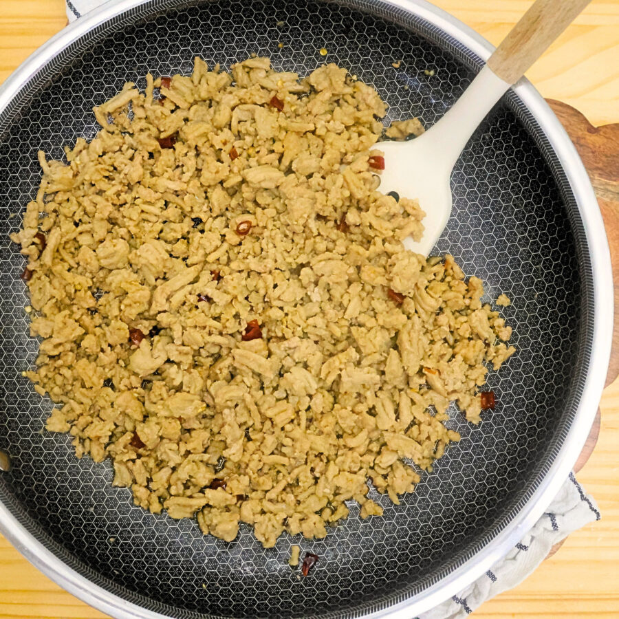 Thai basil chicken in a skillet coated in homemade sauce