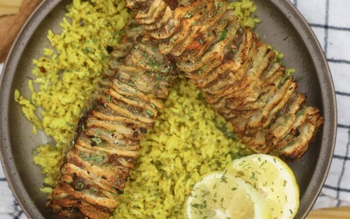 Two Tortilla Kebabs on a bed of seasoned yellow rice with lemon slices