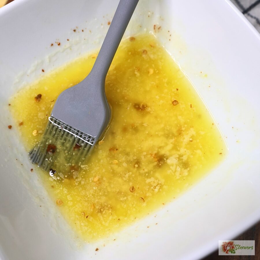 Seasoned butter in a white bowl with a basting brush