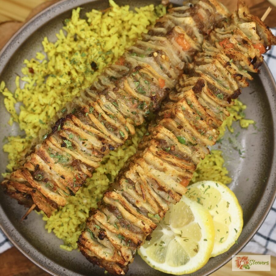 overhead image of tortilla kebabs over a bed of rice with lemon