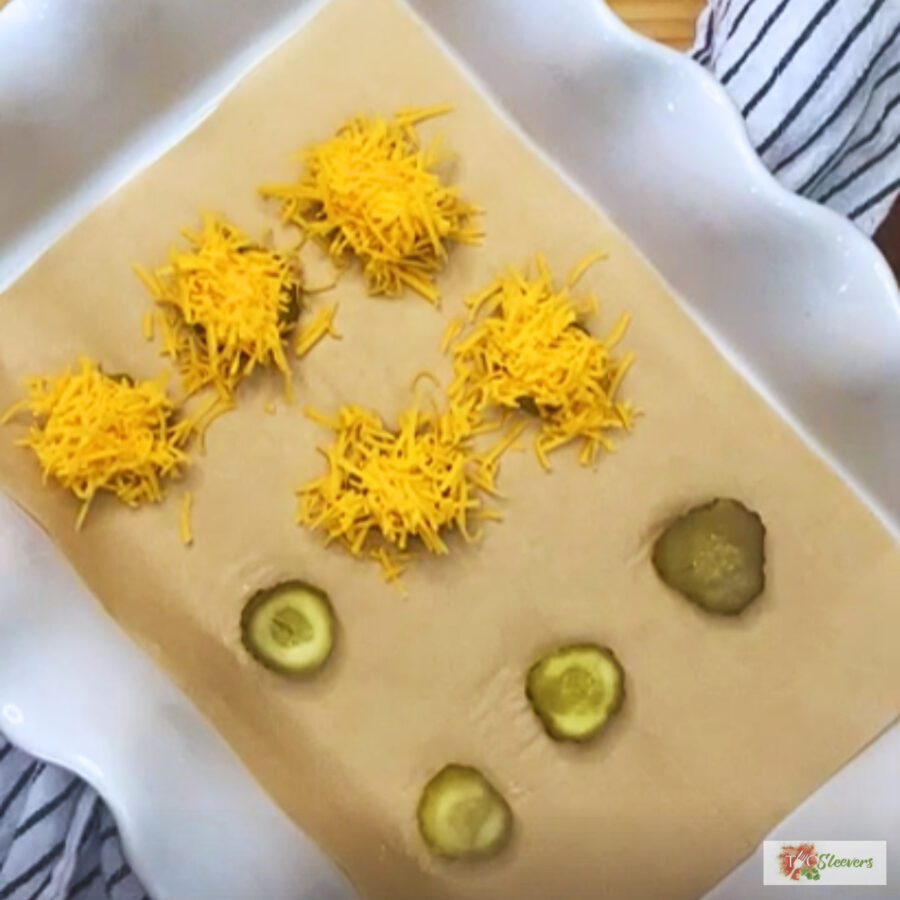 Pickle slices with shredded cheddar cheese on top