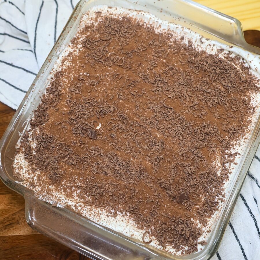 Yogurt tiramisu in a glass baking dish topped with chocolate shavings