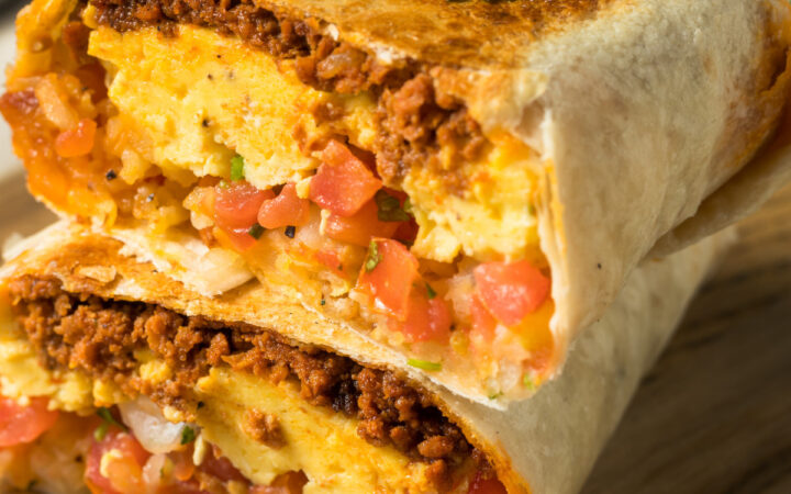 A chorizo breakfast burrito cut in half and stacked on top of each other