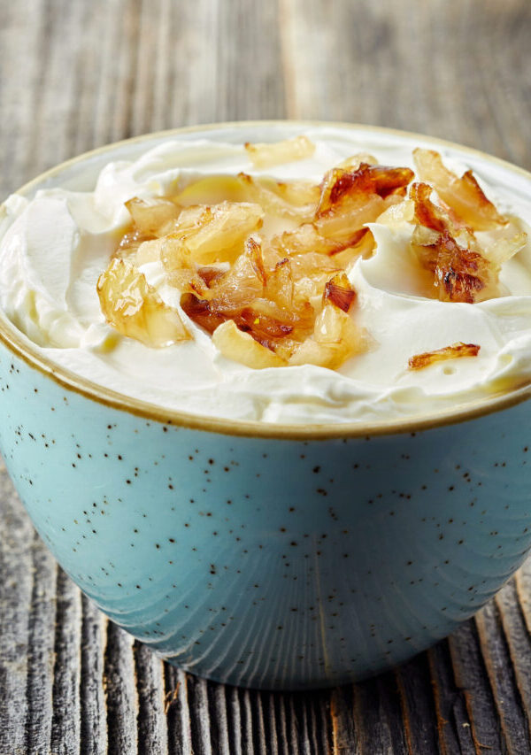 Close up image of French Onion Dip with caramelized onions in a blue bowl